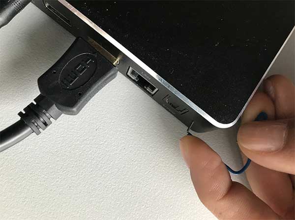 Graffetta che preme il pulsante di reset mentre il cavo di alimentazione è collegato