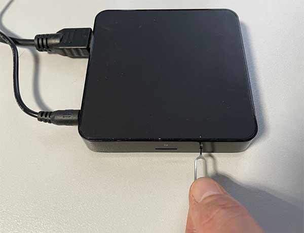 Strumento per l'espulsione della SIM che preme il pulsante di reset mentre il cavo di alimentazione è collegato